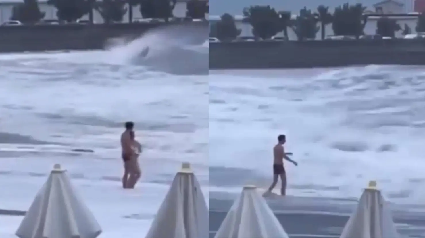 Momento exacto en que una mujer es tragada por el mar mientras caminaba por la orilla | VIDEO