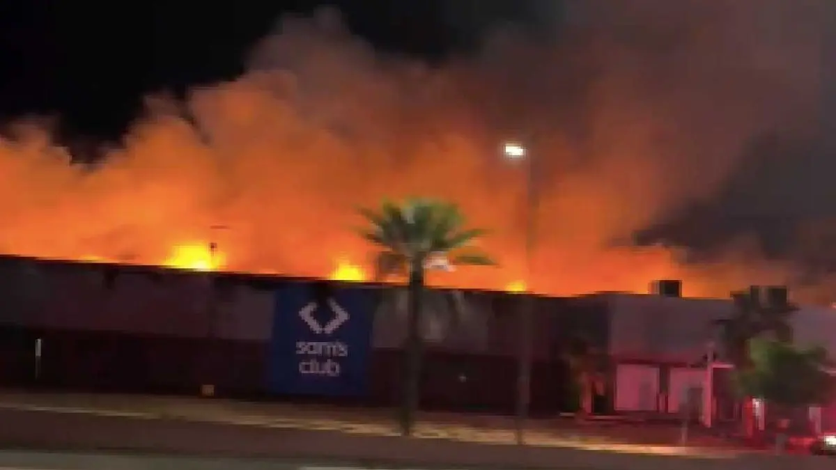 Momento en que una de las paredes del establecimiento colapsa tras ser debilitada por el fuego, durante las labores de emergencia en Hermosillo